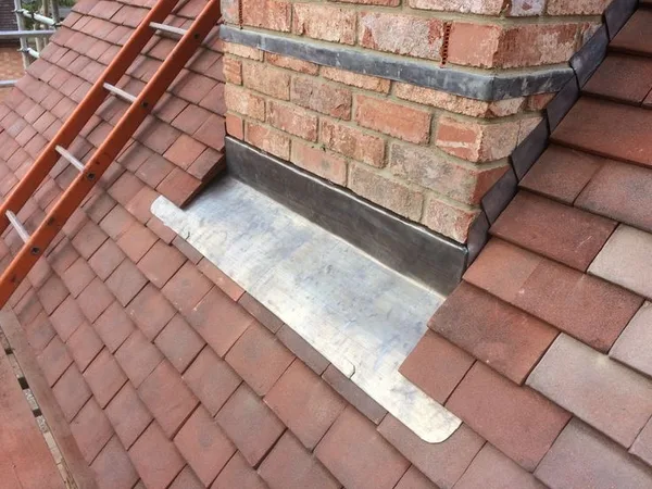 Stepped lead flashing at a brick chimney