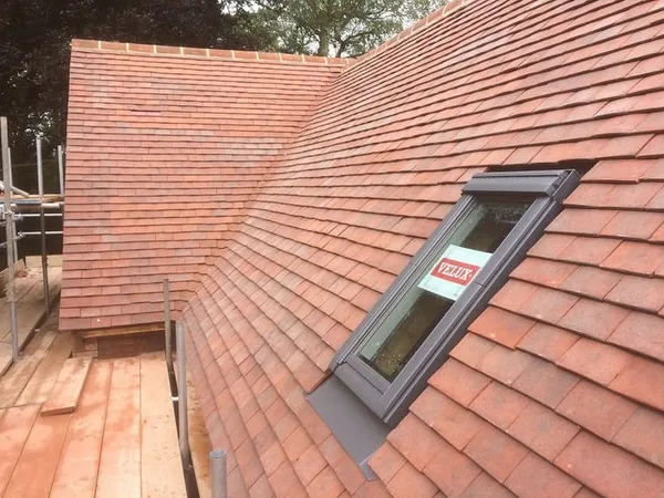 Rooflight and surrounding clay tiles beside scaffolding